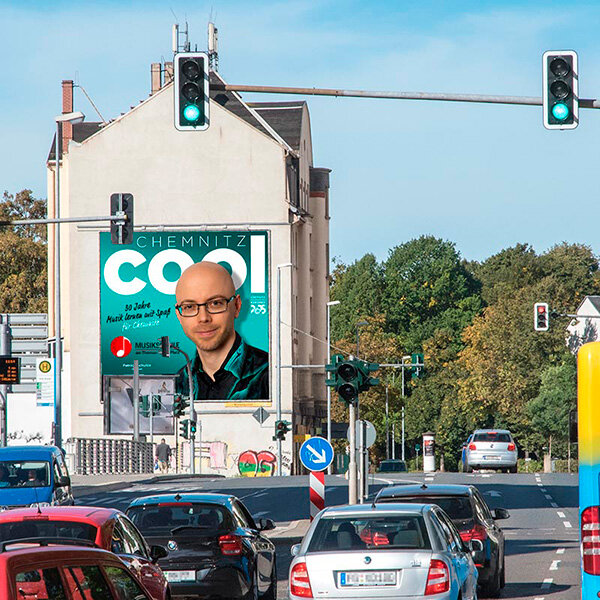 PWC Plakatwerbung Chemnitz - Riesenposter von der Poster Aktion CHEMNITZ COOL mit dem Motiv vom Inhaber der Musikschule Am Thomas-Mann-Platz - Außenwerbung Standort HARTI