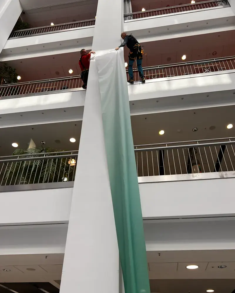 Bannermontage ohne Gerüst im hohen Atrium des TIETZ Chemnitz