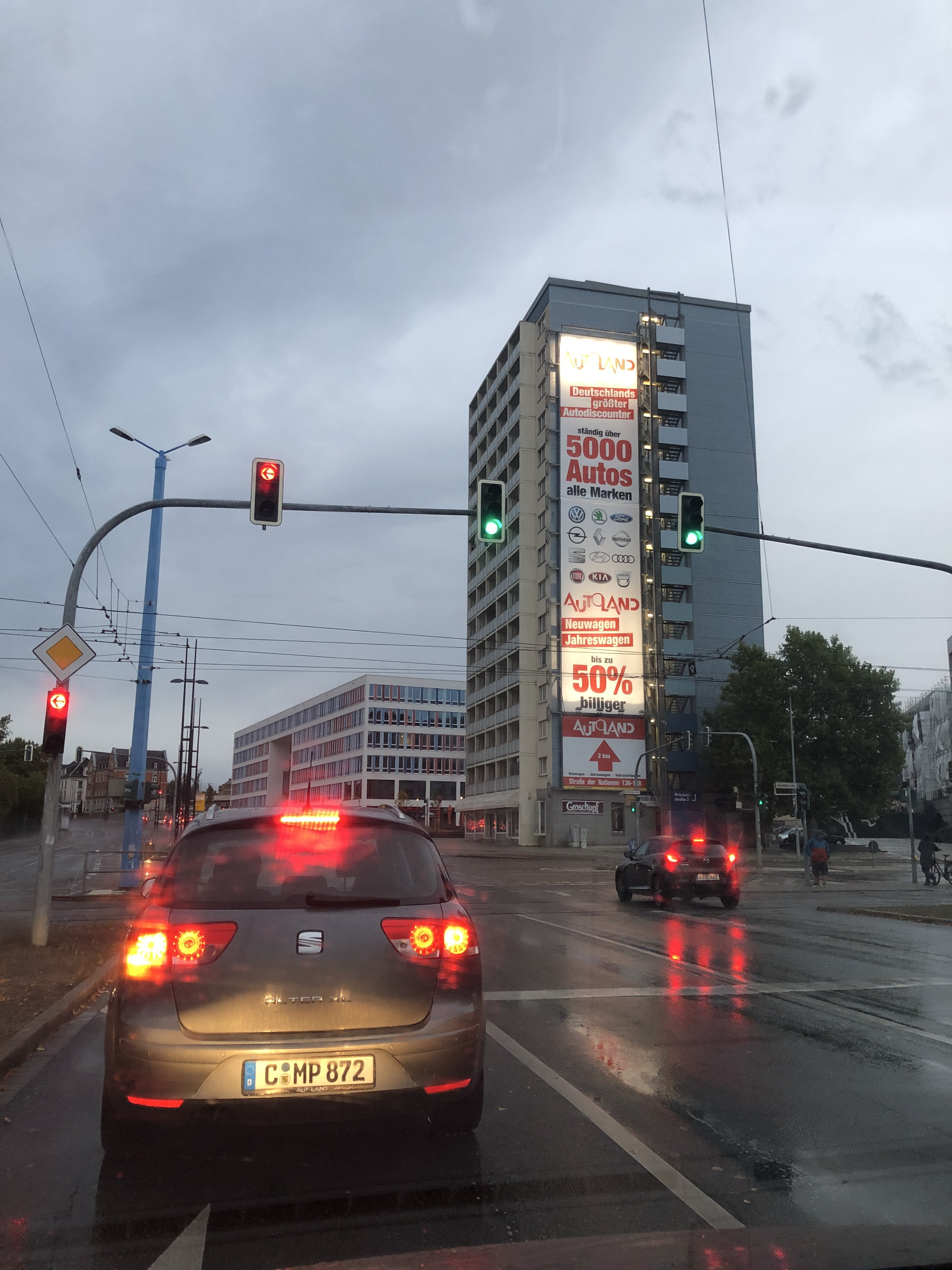 Autoland-Fassadenwerbung am MEGA aus größerer Entfernung über einer regennassen Kreuzung