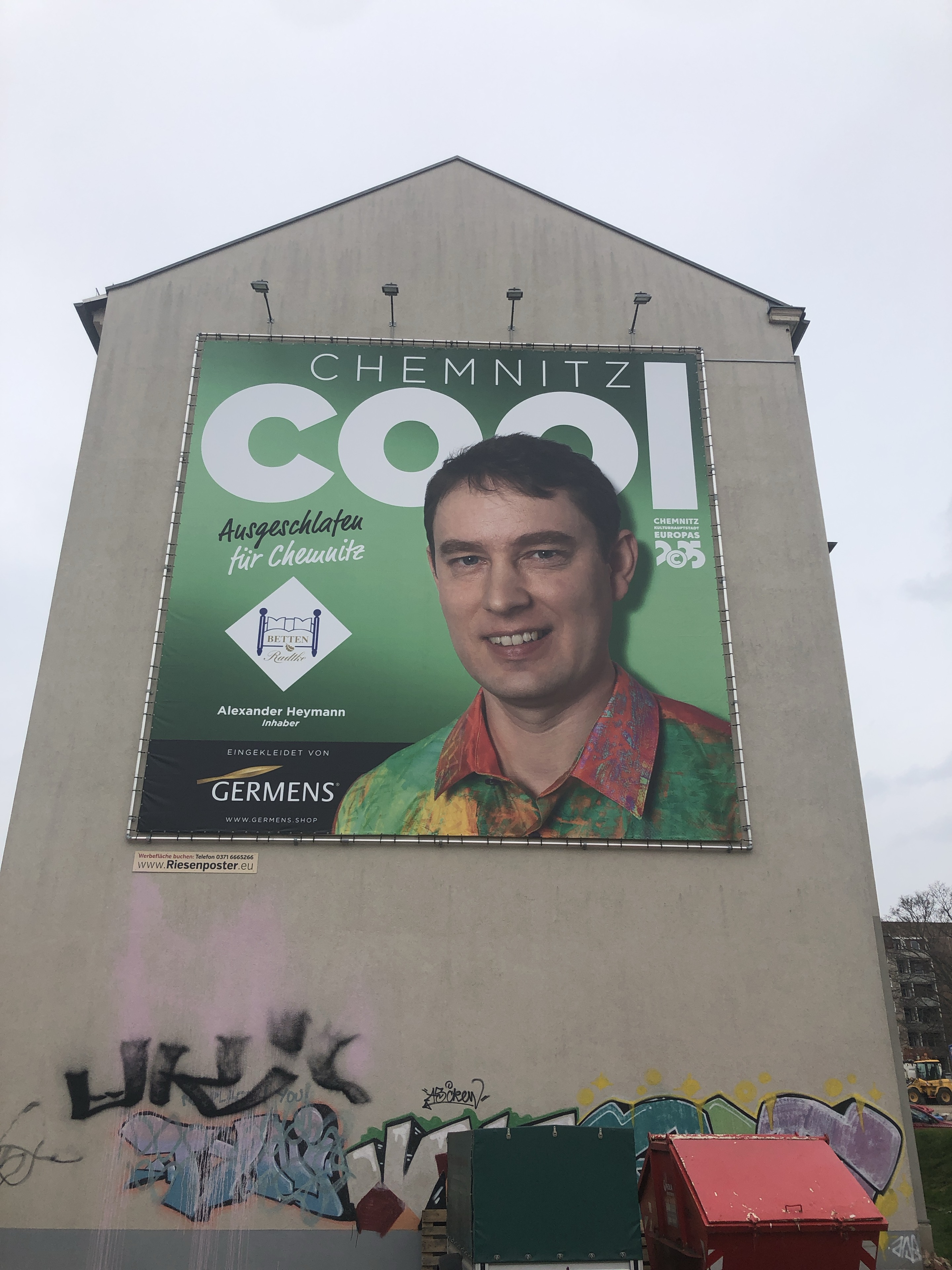 Grünes Chemnitz-cool-Plakat mit dem beschrifteten Porträt von Alexander Heymann an der Augustusburger Straße