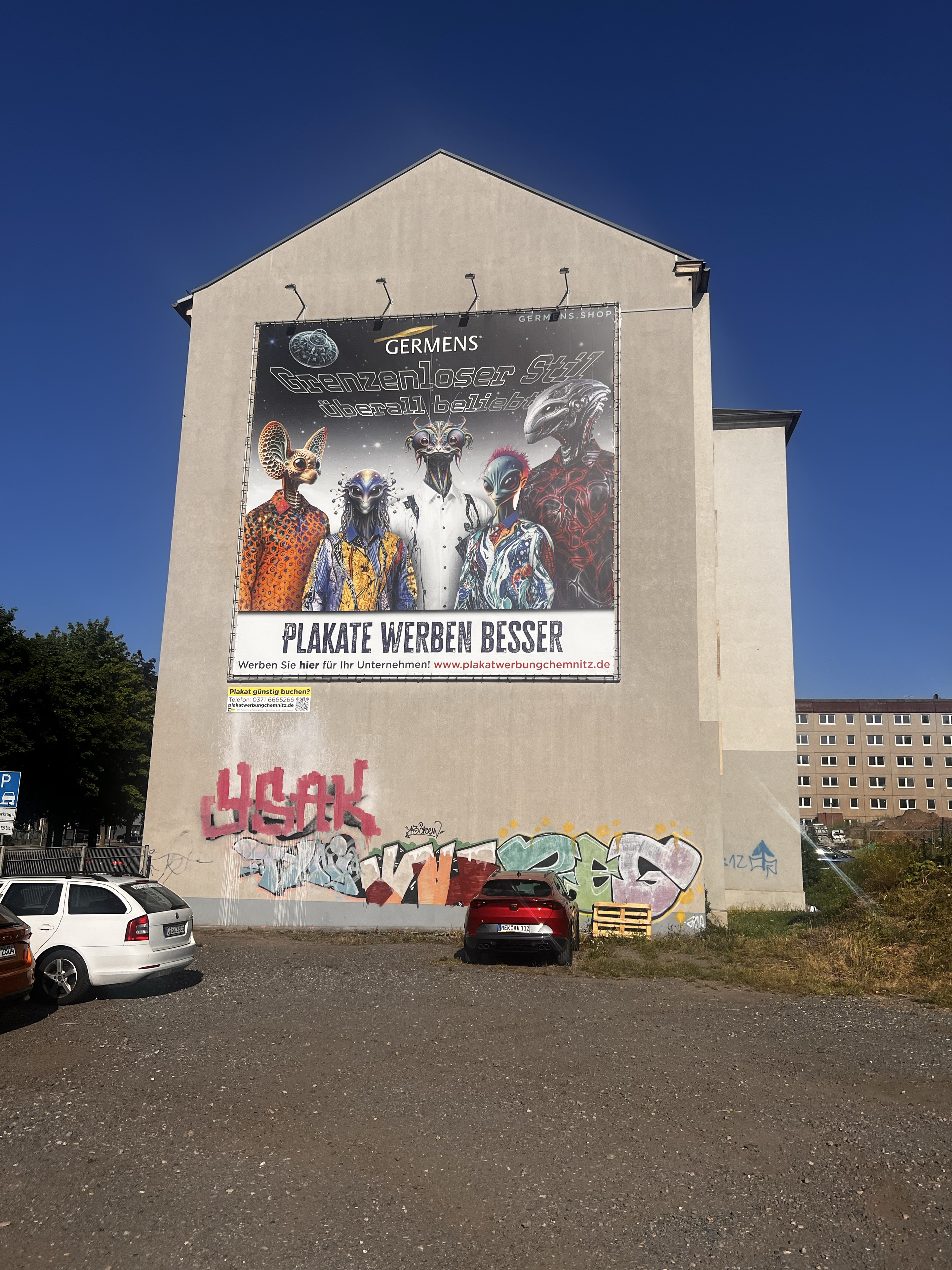 GERMENS-Plakat mit außerirdischen Figuren in Künstlerhemden am AUGUSTE