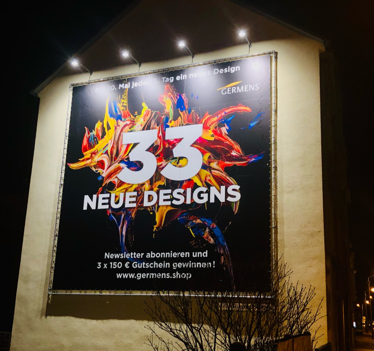 Beleuchtetes GERMENS-Riesenposter mit der Aufschrift 33 neue Designs und bunten Farbformen