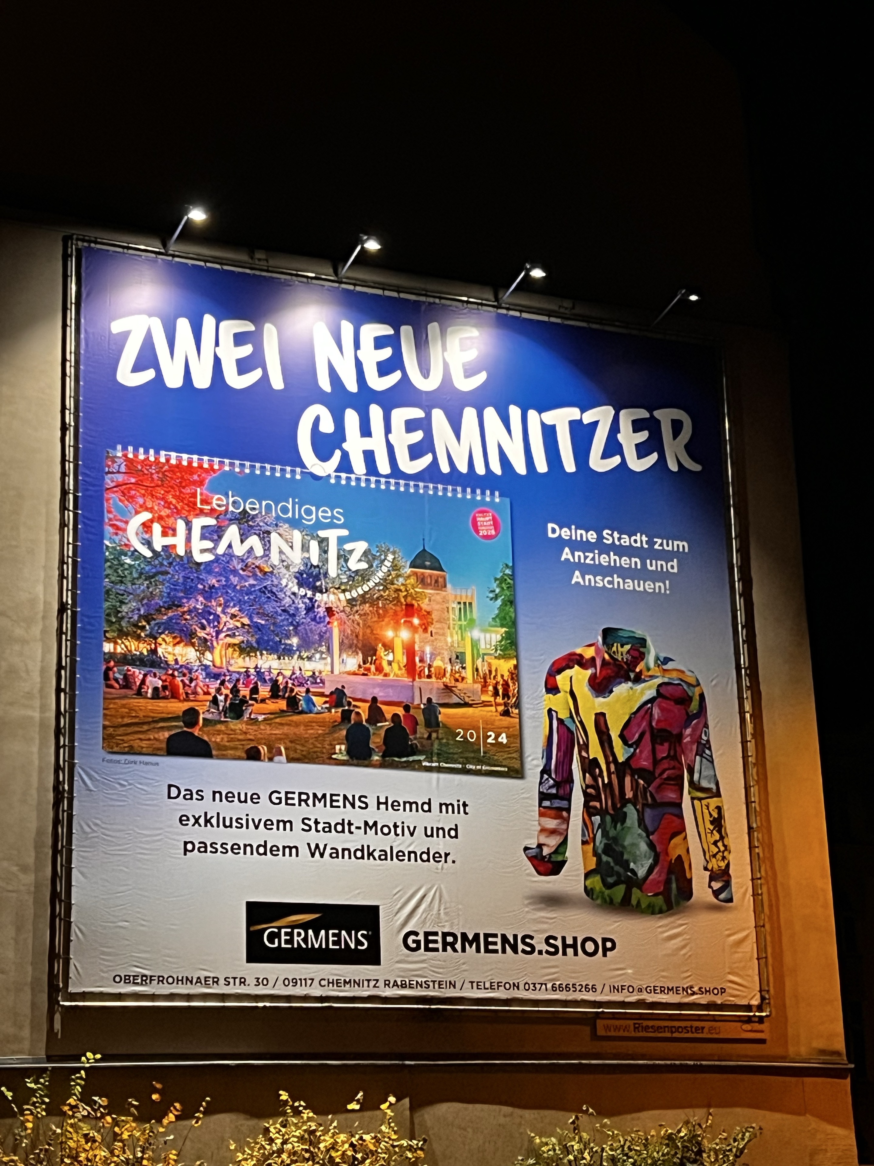 Beleuchtetes GERMENS-Plakat mit Chemnitz-Hemd und Wandkalender 2024