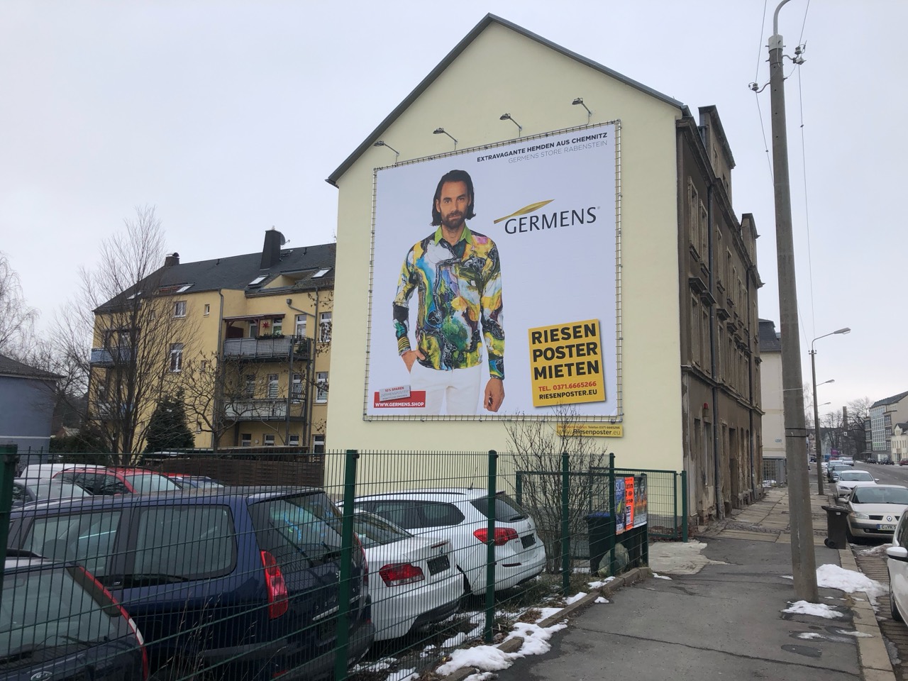 GERMENS-Fassadenwerbung mit farbigem Hemd im winterlichen Straßenumfeld