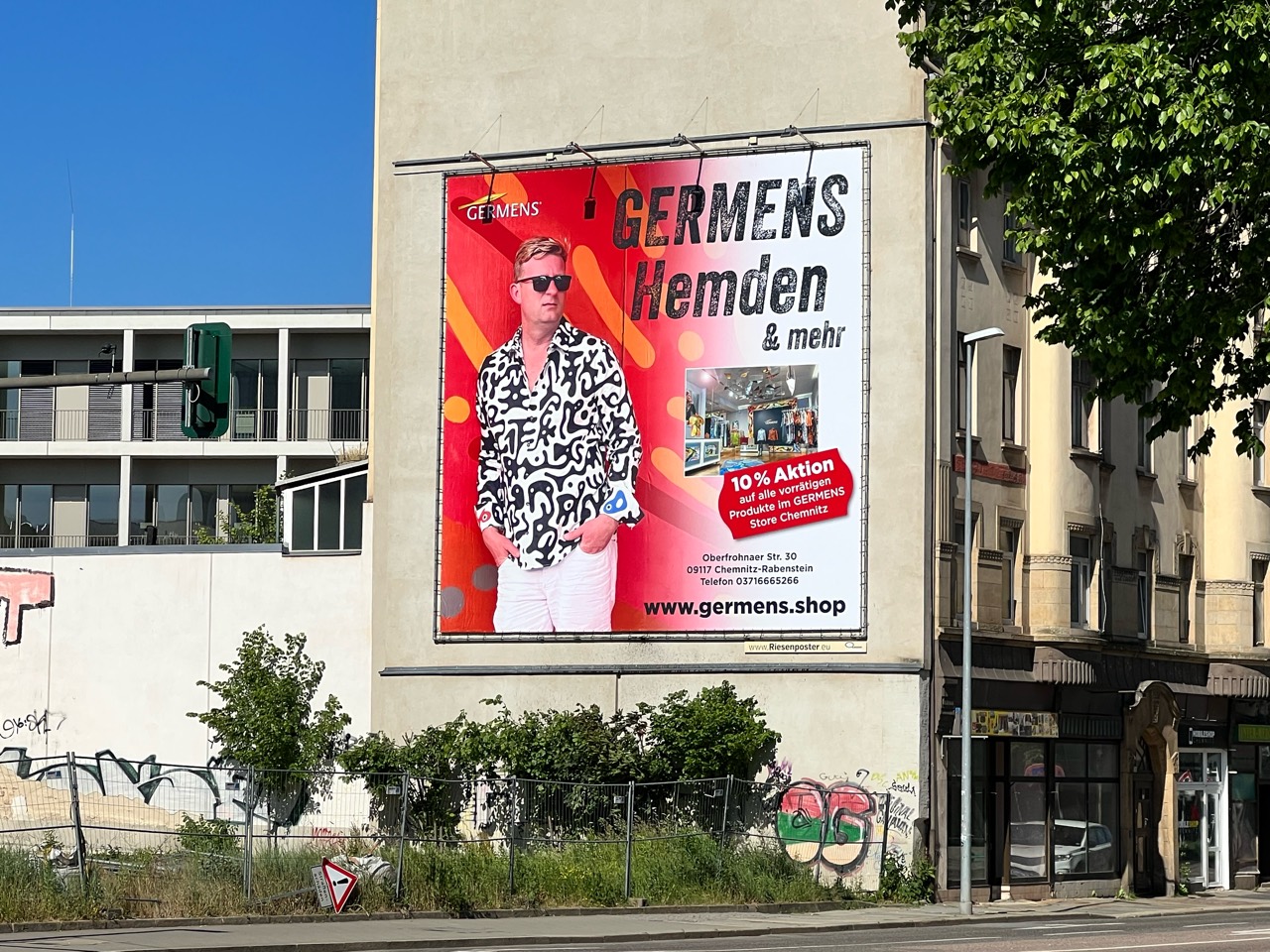 Rotes GERMENS-Plakat Hemden und mehr mit Mann in schwarz-weißem Hemd