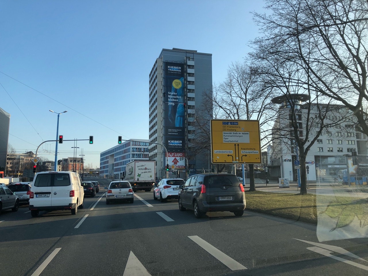 Kieser-Training-Werbung am MEGA aus größerer Entfernung mit Wegweisern und Straßenverkehr