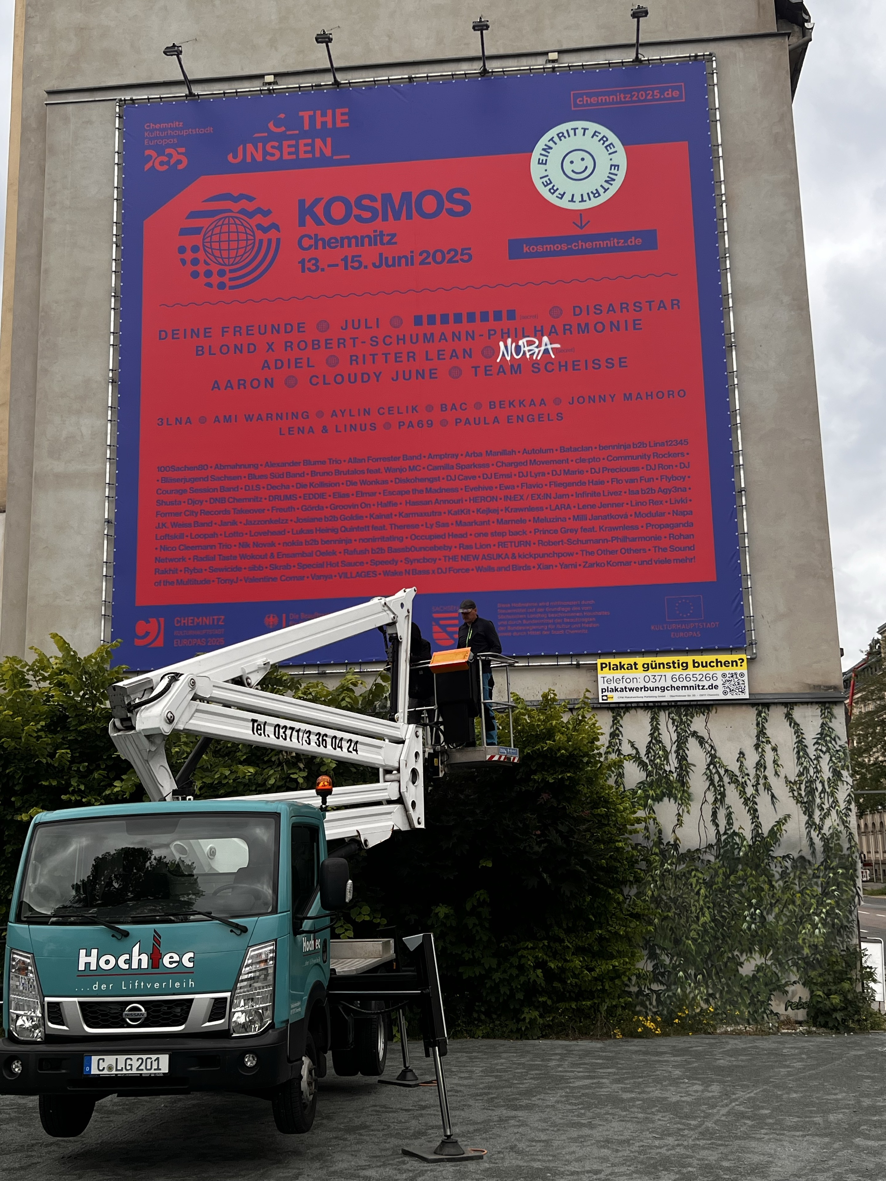 KOSMOS-Chemnitz-Plakat mit Hubarbeitsbühne vor der Giebelfassade