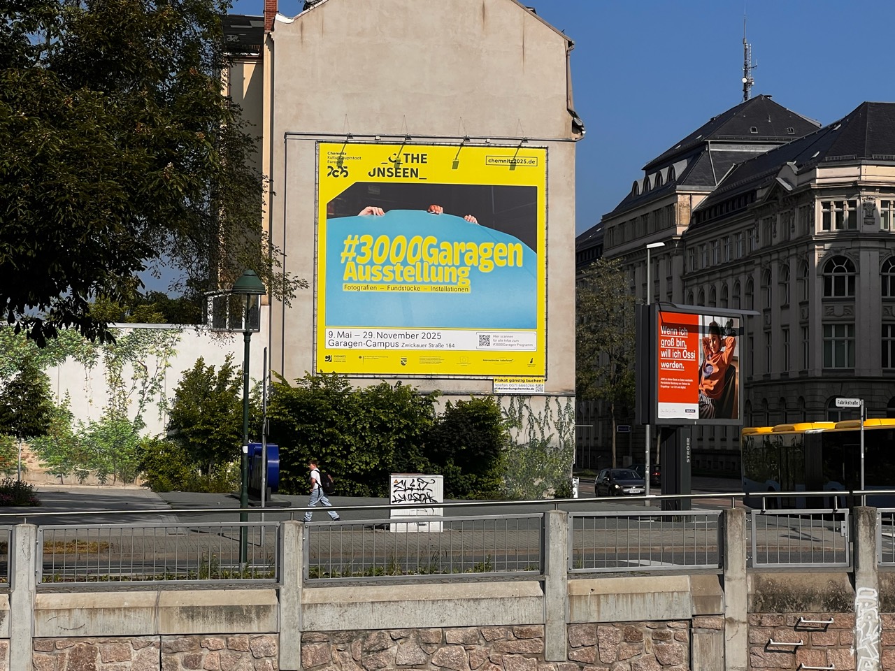 Gelb-türkises Riesenposter zur Ausstellung #3000Garagen am HARTI an der Hartmannstraße