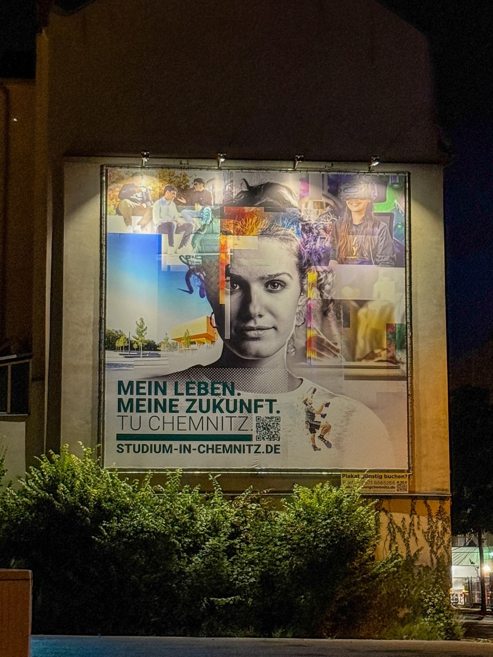 Beleuchtetes TU-Chemnitz-Plakat mit Porträt und Studienwerbeslogan bei Nacht